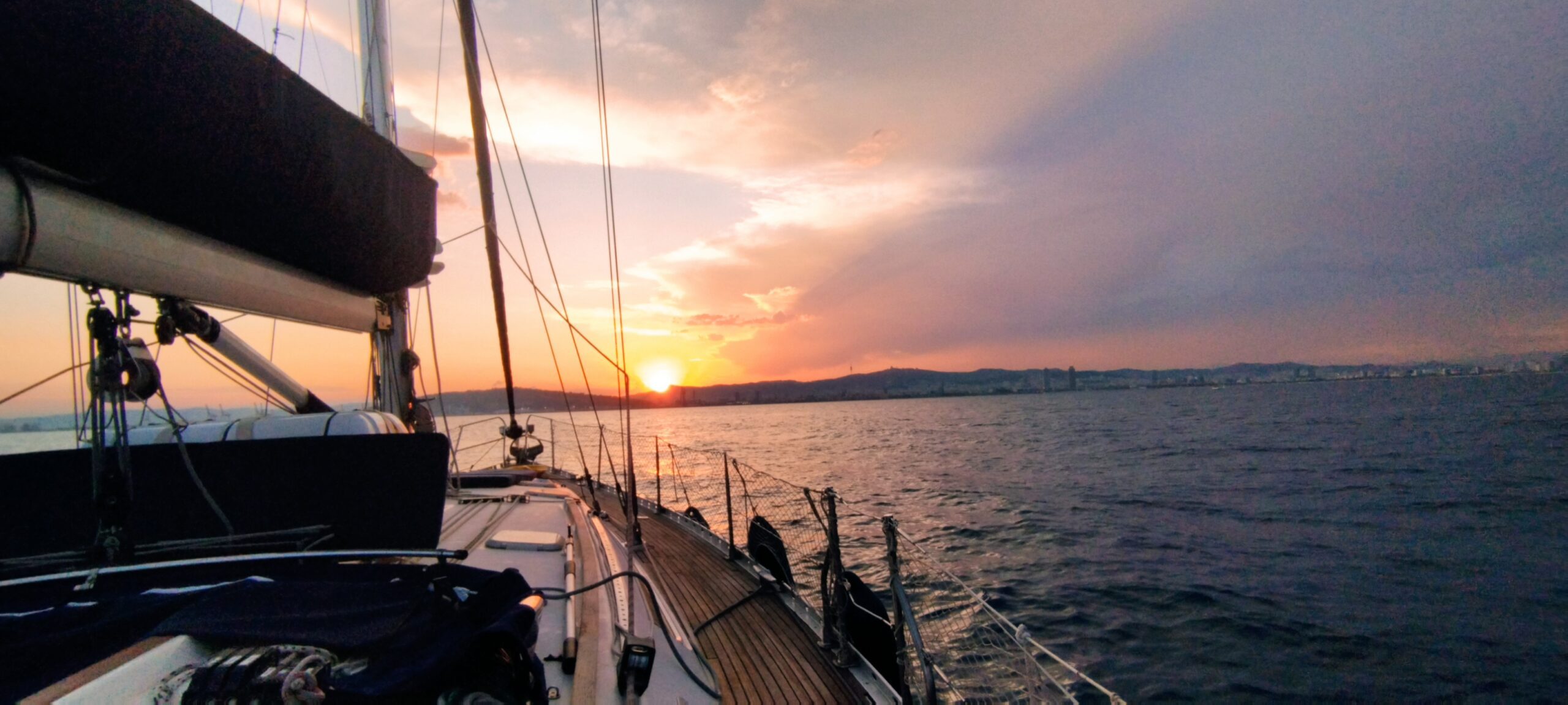 Gourmet sunset aperitif with charcuterie and cava aboard a sailboat in Barcelona